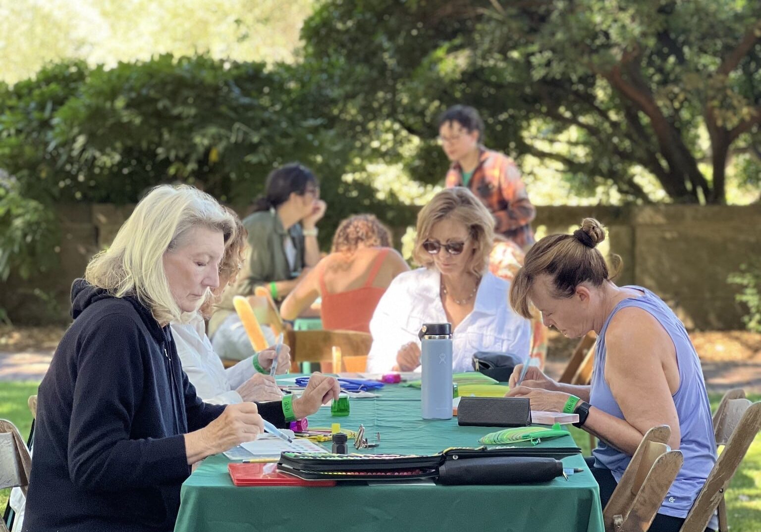 Watercolor painting instruction is presented in the garden as part of Wellness Week 2024.